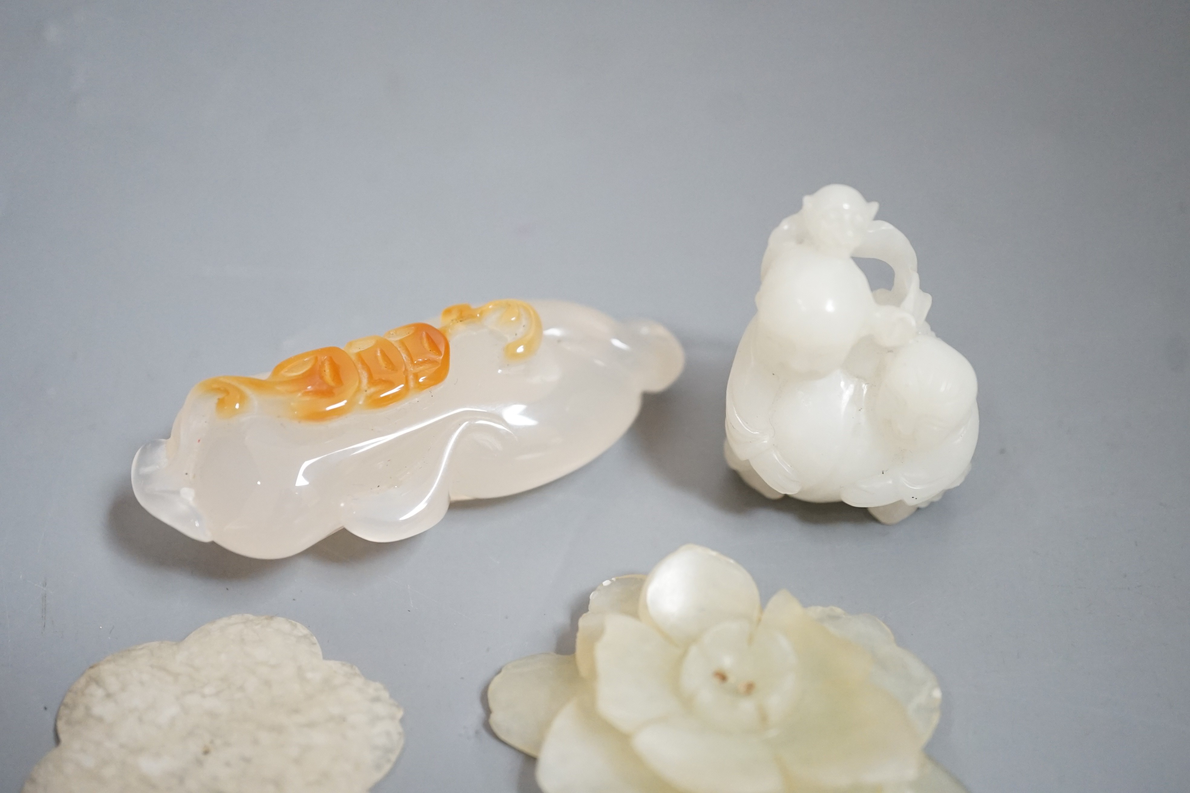 Two Chinese jade flower head carvings, Ming dynasty, a white Jade group of two boys and a monkey and an agate carving (4)